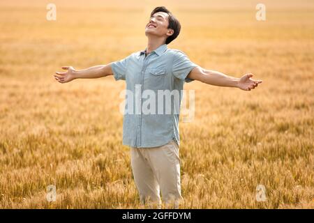 Happy young man in wheat field Stock Photo