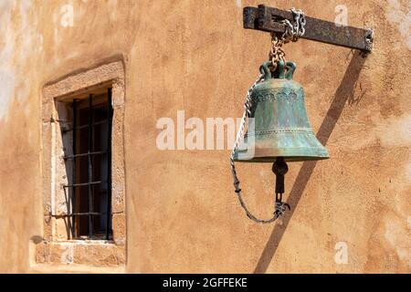 A historical bell in front of a Mediterranean wall Stock Photo