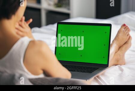 Woman with laptop on bed Stock Photo