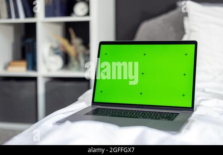 Green screen laptop on bed Stock Photo