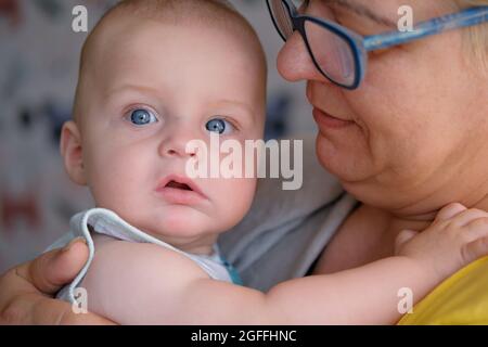 portrait of caucasian mature woman and cute baby with blue eyes Stock Photo