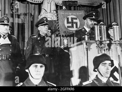 Reichsführer SS Himmler speaking to the East Prussian Volkssturm battalions in October 1944. Alongside the Reichsführer-SS Obergruppenführer Hans Lammers (next to Himmler) and Generaloberst Heinz Guderian (far left, partly cut off). Credit: German Bundesarchiv Stock Photo