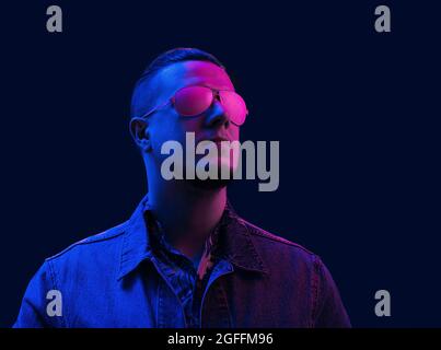 Neon light in glasses of a man. Futuristic cyber studio portrait