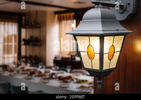 Long table before celebration in restaurant, empty glasses and appetizers, beg terrace windows. Cozy elegant atmosphere in luxury restaurant Stock Photo
