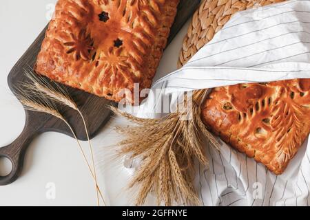 Homemade baked pies with mushrooms and berry cake cooling on cloth with copy space. Flat lay, top view Stock Photo
