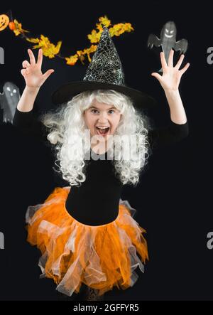 A cheerful girl in a white wig and a witch costume scares. Horror