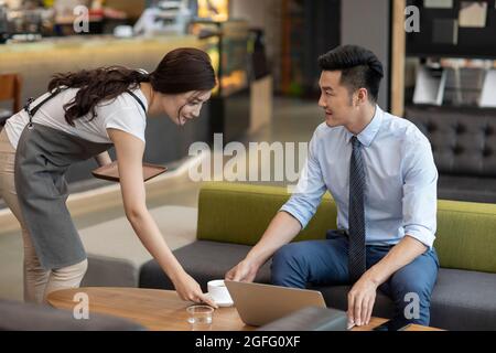 Businessman drinking coffee in café Stock Photo