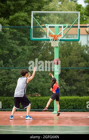 Father and daughter playing basketball on playground Stock Photo