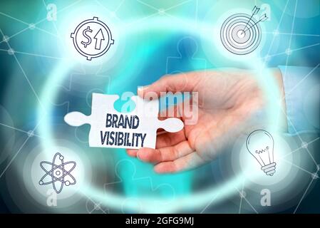 Text caption presenting Brand Visibility. Business idea frequency at which showing see your brand in search results Hand Holding Jigsaw Puzzle Piece Stock Photo