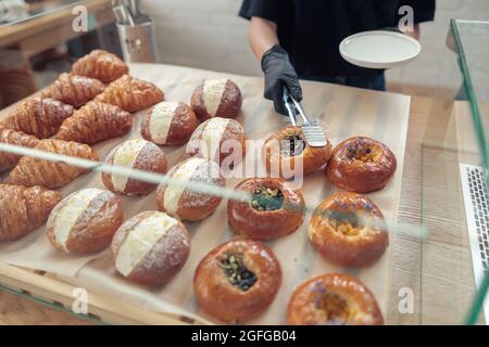 Woman in gloves putting baked goods on snowcase Stock Photo