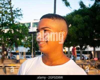 Riohacha, La Guajira, Colombia - May 26 2021: Portrait of a Young Latin Man Looking at the Sunset with Trees and Blue Sky in the Background Stock Photo