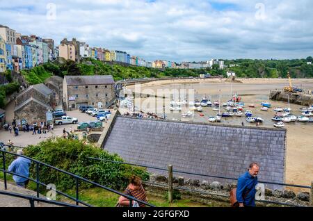 A view looking across Tenby Harbour towards and the north beach with colourful houses on the side.
