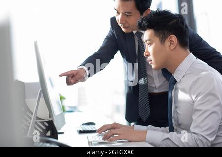 Confident businessmen using computer in office Stock Photo