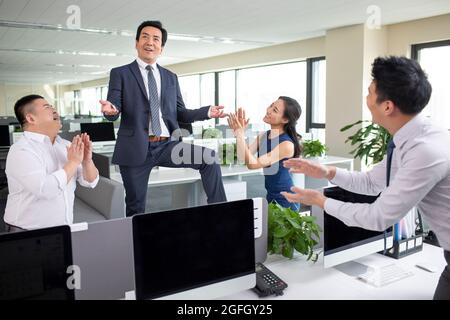 Business people clapping hands in office Stock Photo