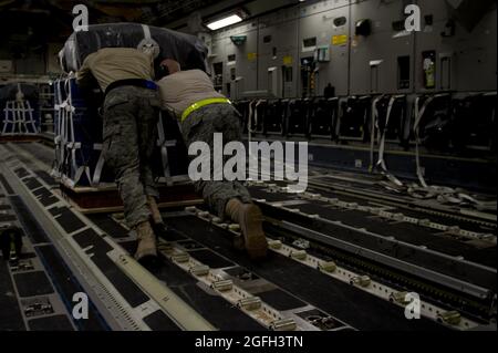 Members from the 8th Expeditionary Air Mobility Squadron load cargo onto a C-17 Globemaster III for an air delivery mission to Afghanistan. The C-17 aircrew air delivered the cargo which consisted of fuel and other various supplies to a remote forward operating base in Afghanistan. Stock Photo