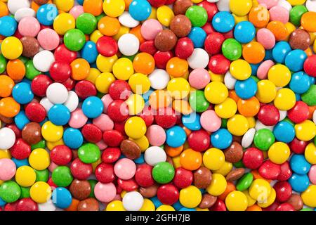 Colorful small chocolate dragee. Multicolored button-shaped candies as background, close-up. Stock Photo