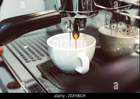 prepares espresso in his coffee shop; close-up Stock Photo