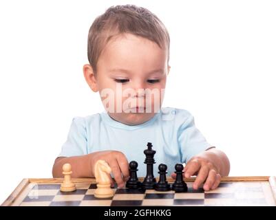 little boy staring at the chess pieces isolated on white background Stock Photo