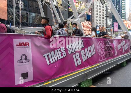 New York, United States. 25th Aug, 2021. People wait to ride the Times Square Ferris wheel on opening day in Times Square, New York City.The 110-foot Times Square Ferris Wheel, located on Broadway between 47th and 48th street, will be open until September 14th, 2021. (Photo by Ron Adar/SOPA Images/Sipa USA) Credit: Sipa USA/Alamy Live News Stock Photo