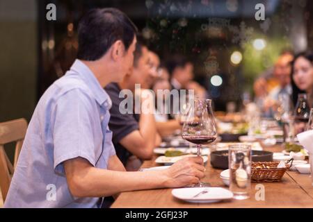 Holiday celebration concept friends having christmas dinner party and drinking red wine at home. Stock Photo