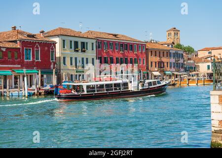 Actv (municipal company for public transport) Ferry Boat or Vaporetto with tourists in motion in a canal of the Murano island, Venice, Italy. Stock Photo