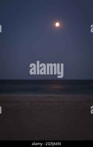 Sea coast and moon at night Stock Photo