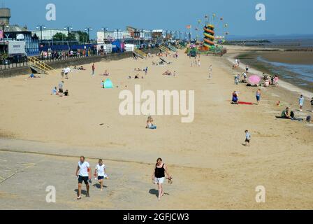 People enjoying the summer sunshine on a sandy beach in the picturesque seaside town of Cleethorpes, Lincolnshire. UK. Stock Photo