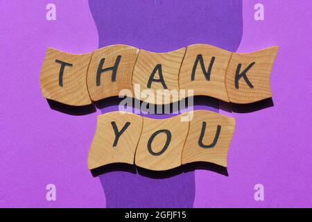 Thank You, words in wooden alphabet letters isolated on blue and purple background as banner headline Stock Photo