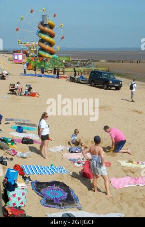 People enjoying the summer sunshine on a sandy beach in the picturesque seaside town of Cleethorpes, Lincolnshire. UK.England. Stock Photo