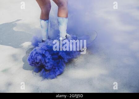 Skaters with colored smoke bombs. Professional skateboarders having fun at the skate park Stock Photo