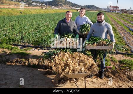 Happy farm family with freshly harvested scallions Stock Photo