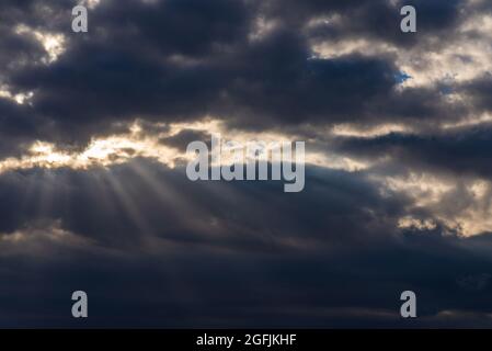 Rays of light shining throug dark clouds.Beautiful dramatic sky with sun rays.dramatic sky sun rays. Stock Photo