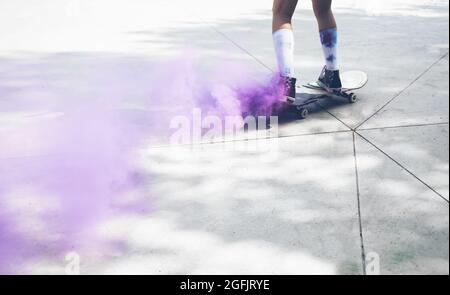 skaters with colored smoke bombs. Professional skateboarders having fun at the skate park Stock Photo
