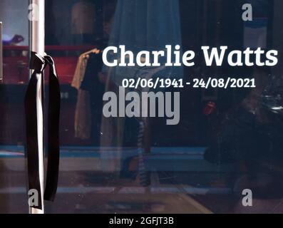 London, United Kingdom. 25th Aug, 2021. A black ribbon is tied to the door next to a Charlie Watts tribute at The Rolling Stones store in Carnaby Street. The legendary drummer died on 24th August 2021, aged 80. Stock Photo