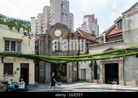 Shanghai, Shanghai, China. 26th Aug, 2021. On August 26, 2021, on both sides of Jiangyin Road in Huangpu District, Shanghai, there are mostly two-story Shikumen Lane houses. There are a lot of green vines along the outer wall of the street, which is nothing special at first glance. Observing carefully, these green leaves are actually simulated leaves with some wires that cannot be hidden inside. Compared with the black wires, this decoration looks much more beautiful. Visual pollution of various overhead lines in old communities is often difficult to deal with. However, in the blocks of Stock Photo