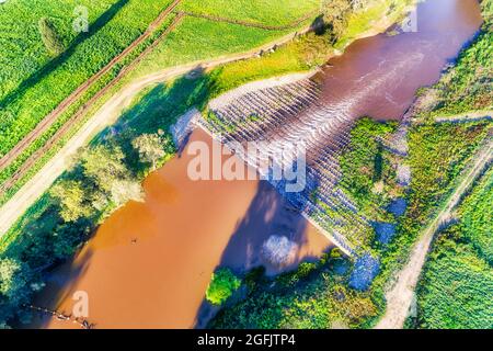 Weir of fishing crossing on Macquarie river in Dubbo town of Australian Great Western plains - aerial top down view. Stock Photo