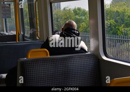 Newcastle. Tyne and Wear. England. 05-27-21. Passenger looking out of a window on one of the city's rapid transit metro trains. Stock Photo