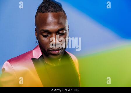 Artistic portrait with gel lights. Handsome man posing on colored backgrounds Stock Photo