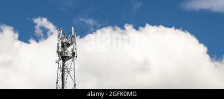 Bottom perspective pov of modern metal steel mobile 5g network wireless telecom tower against clear blue sky background on bright day. Microwave Stock Photo
