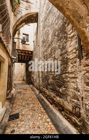 Narrow alley covered with stone arches in Avignon old town. Stock Photo