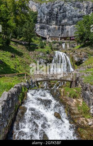 Ensemble of buildings with waterfall in front of the St. Beatus Caves, Beatenberg, Bernese Oberland, Switzerland, Europe Stock Photo