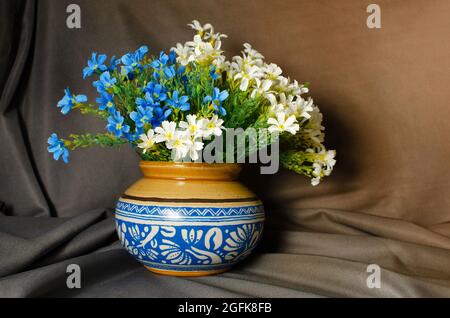 Traditional ceramic pot with Blue design and flowers on Brown background Stock Photo