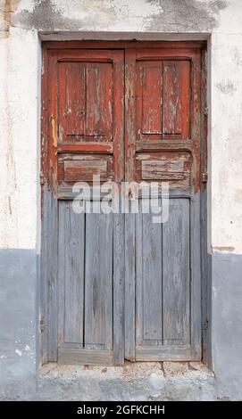 Old, heavily weathered, gray red wooden door Stock Photo