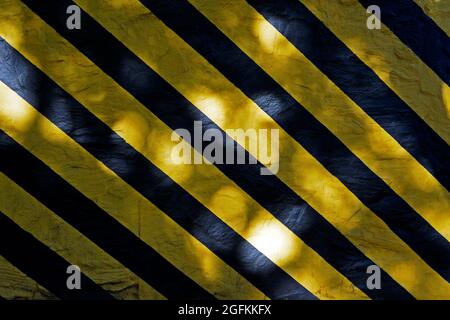 Wall surface painted with black and yellow stripes Stock Photo