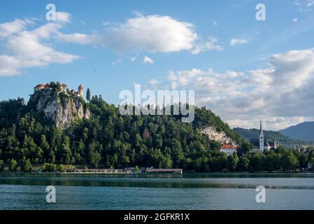 Bled Castle on a cliff overlooking Lake Bled surrounded by clouds