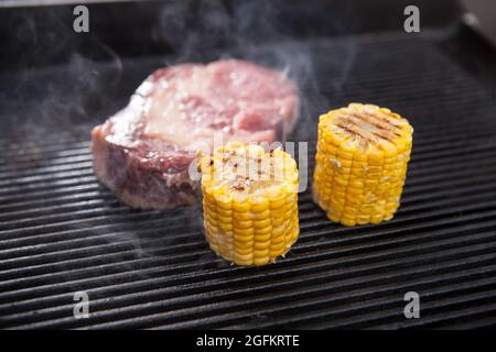Fresh raw marbled beef grilling with sweet corn Stock Photo
