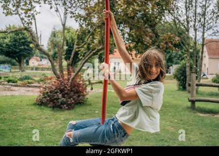 happy girl swinging on a disch swing in park Stock Photo