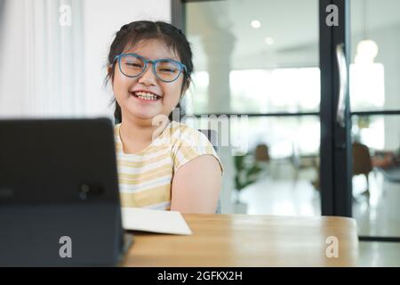 Girl children using laptop computer, studying through online. Stock Photo