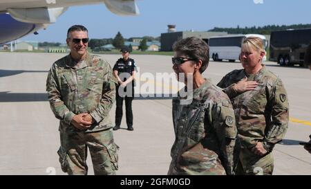 Maj. Gen. Paul Knapp, Wisconsin Adjutant General and Wisconsin National Guard commander, and Brig. Gen. Joane Matthews, the Wisconsin Deputy Adjutant General, greet Afghans as they disembark the aircraft on Volk Field at Camp Douglas, Wisconsin, Aug. 22, 2021. The Department of Defense, in support of the Department of State, is providing transportation and temporary housing in support of Operation Allies Refuge. This initiative follows through on America's commitment to Afghan citizens who have helped the United States, and provides them essential support at secure locations outside Afghanista Stock Photo