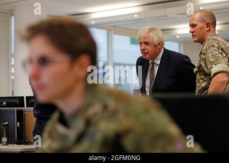 Prime Minister Boris Johnson observes the operations room for the Afghan Relocation and Assistance Policy during a visit to Northwood Headquarters, the British Armed Forces Permanent Joint Headquarters, in Eastbury, north west London, where he met with personnel working on the UK operation in Afghanistan. Picture date: Thursday August 26, 2021. Stock Photo